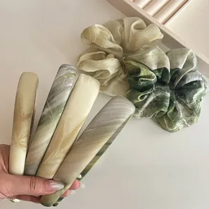 Close-up of green bamboo leaf pattern on silk-like satin hairbands and scrunchies