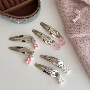 Detail van 6 zilveren metalen haarspelden met roze en witte hars beerhangers