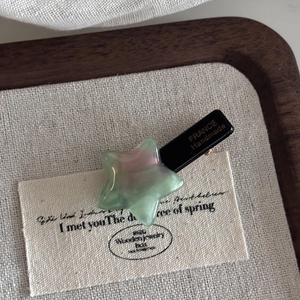 Close-up of star acetate hair clip with green-pink gradient and France handmade engraving