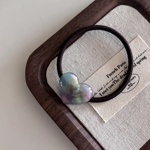 Gros plan d'un élastique à cheveux cœur en acétate violet avec inscription France handmade