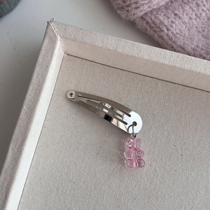 Detail van een gummibeer haarclip met zilveren metalen speld en roze harsbeertje hanger