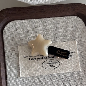 Detailed macro of a cream star hair clip with France Handmade gold lettering