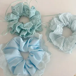 Lot de trois chouchous bleu clair en satin de soie avec bordures en dentelle délicate