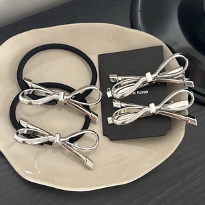Silberne Haarklammern mit Schleife und elastische Haargummis im minimalistischen Metalldesign