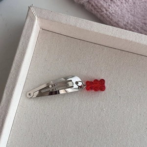 Detail van een zilveren haarclip met een rode hars gummibeertje hanger voor meisjes