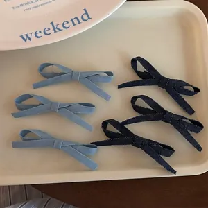 Set of 6 sweet denim bow hair clips in light and dark blue styles on a beige tray