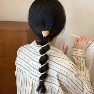 Gradient heart spiral hair tie for ponytails shown on model in a cozy aesthetic setting
