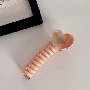 Pink orange spiral phone cord hair tie with a resin heart charm for women's hairstyles