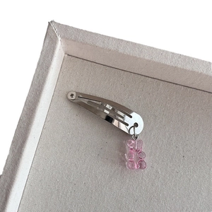 Zilveren metalen haarclip met doorschijnende roze gummibeer hanger op een presentatieblad