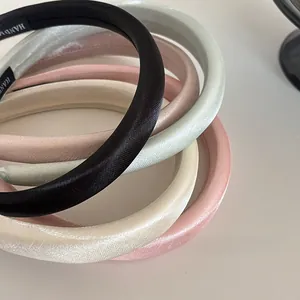 Detail von gepolsterten Schwamm-Stirnbändern mit Satingewebe in Schwarz, Grün und Beige
