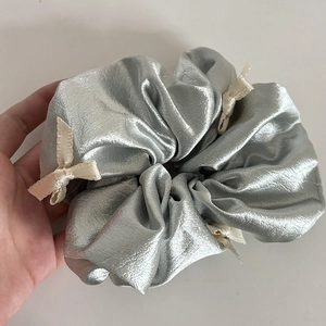 Silver metallic scrunchie featuring cream ribbon bows for a balletcore hair style