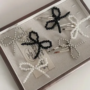 Détails de barrettes à nœud argentées avec perles et perles sur un plateau