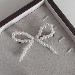 Barrette à cheveux élégante avec nœud en perles et pince crocodile argentée sur plateau