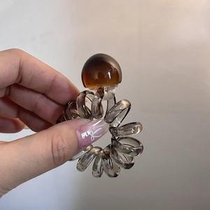 Detail of grey spiral telephone wire hair tie with a translucent amber bead accessory