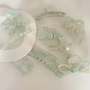 Detail of light green acetate claw clips in marble texture and various elegant shapes