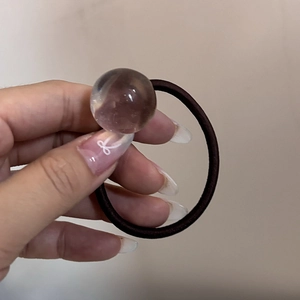 Dettaglio dell'elastico per capelli ad alta elasticità con una perla sferica trasparente