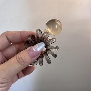 Close-up of translucent spiral phone cord hair tie with an amber decorative bead