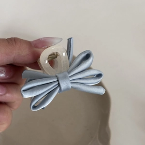 Light blue silk bow hair claw clip with transparent acrylic base for elegant hairstyles