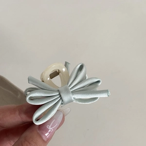 Detailed close-up of a mini bow hair claw clip featuring light green satin ribbon detail