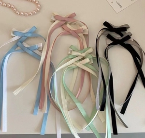 Flat lay of colorful double-layered balletcore bow hair clips with long ribbons