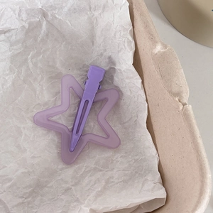 Détail d'une pince à cheveux étoile lavande mate sur un plateau en papier recyclé