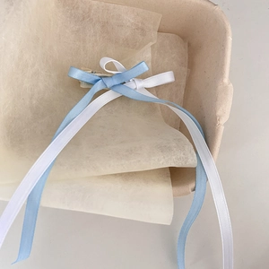 Close-up of dual-layer blue and white silk ribbon bow hair clips with long streamers