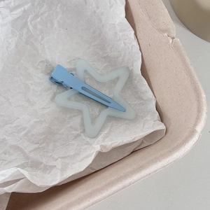 Détail de la pince à cheveux étoile couleur bonbon avec étoile vert mat sur clip bleu
