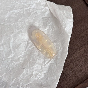 Handmade French acetate hair clip in champagne gold on elegant textured paper background