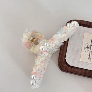 Detail of colorful lace flower hair claw clip with elegant pearls and metal spring