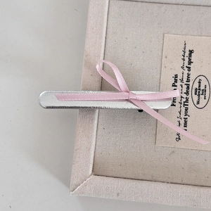 Pince à cheveux nœud en ruban rose avec base argentée sur boîte de présentation bijoux