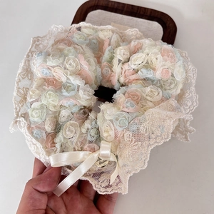 Detailed view of iridescent mesh flower hair scrunchie with lace and ribbon bow