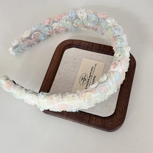 Detailed macro view of lace flower headband with colorful macaron petals and pearls