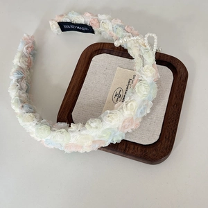 Detailed macro view of handmade lace mesh flowers with pearl bows and woven logo label