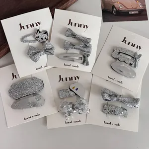 Détail de pinces à cheveux à paillettes argentées avec nœuds et motifs de chat
