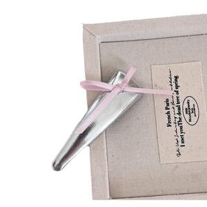 Barrette à cheveux en métal argenté avec nœud en soie rose sur un coffret à bijoux
