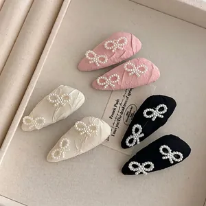 Elegant pearl bow hair clips set in pink, cream, and black colors for stylish women