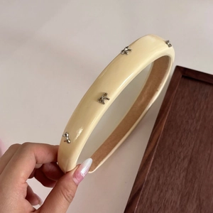 Cerchietto beige lucido con fiocchi in metallo argentato e design interno antiscivolo