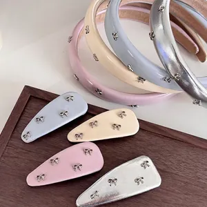 Set cerchietto e molletta in ecopelle con fiocchi metallici rosa, blu, beige e argento lucido