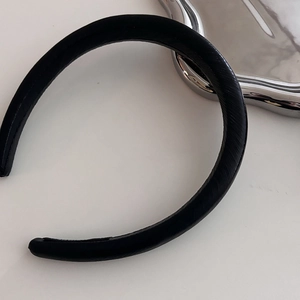 Detailed top view of a black faux leather headband with a premium diagonal textured finish