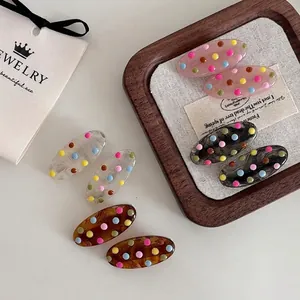 Set of retro colorful polka dot hair clips in various patterns on a wooden tray