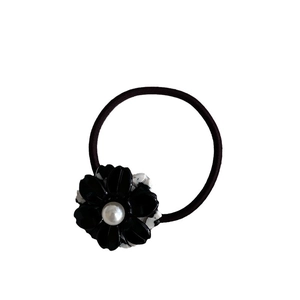 Elegant black acetate flower hair tie with pearl center and marble pattern texture