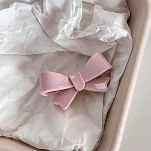 Dettaglio di un fermaglio per capelli a fiocco rosa opaco in scatola regalo