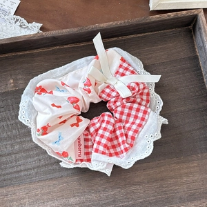 Süßer Erdbeer-Haargummi mit rotem Gingham, Spitze und Schleife auf Holztablett