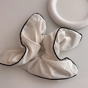 Minimalist white scrunchie with black trim edging made of soft chiffon fabric