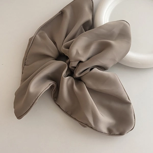 Mocha satin silk oversized scrunchie for women hair styling on white ceramic plate