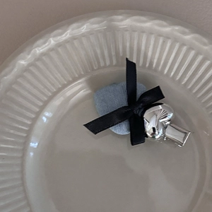 Barrette à cheveux nœud en denim bleu avec détail cœur argenté sur plat blanc