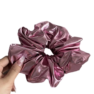 Metallic pink scrunchie made of shiny faux leather fabric for elegant hair styling