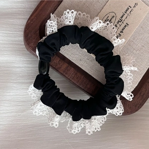 Elegant black lace scrunchie with white trim and decorative bead on vintage fabric