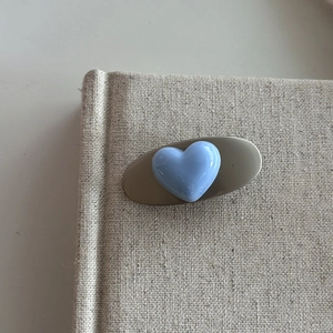 Silver hair clip with a glossy blue 3D heart on an oval base for sweet girl styling