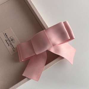 Elegant pink satin bow hair clip with multi-layer design in a French minimalist style